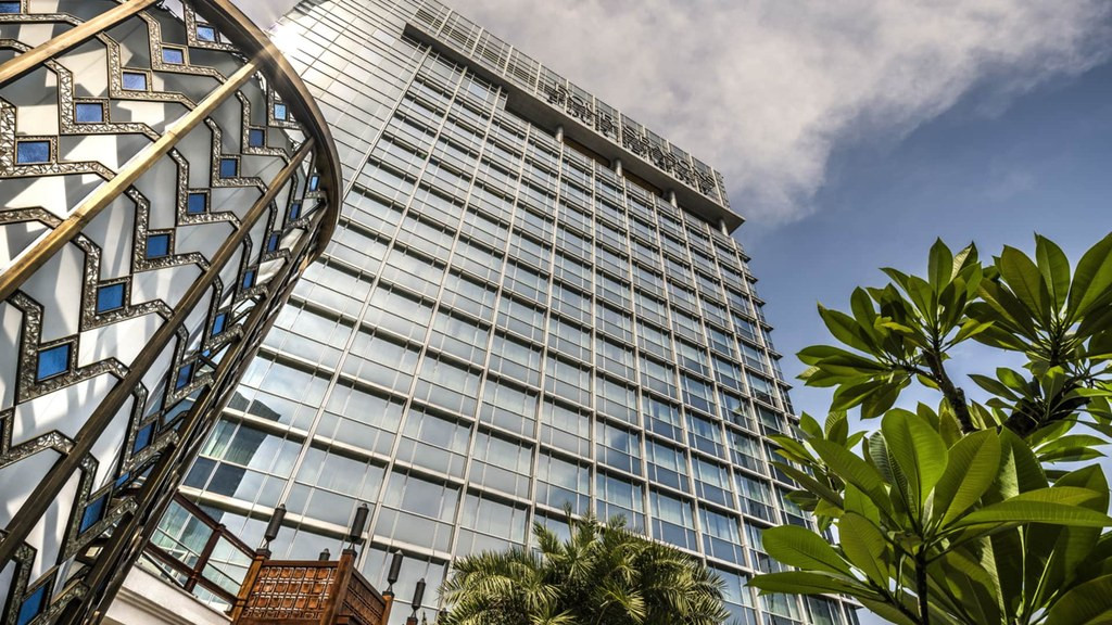 四季雅加达外观，Capital Place 玻璃幕墙大楼仰视，前景为印尼图案彩绘玻璃